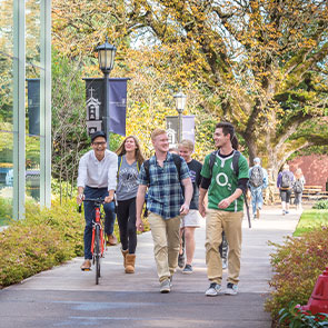 Group of students walking and biking down path. Read about Closely Held Business Stock