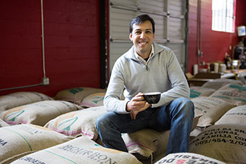 Photo of a man sitting on bags of coffee beans. Link to Life Stage Gift Planner Under Age 45 Gifts.